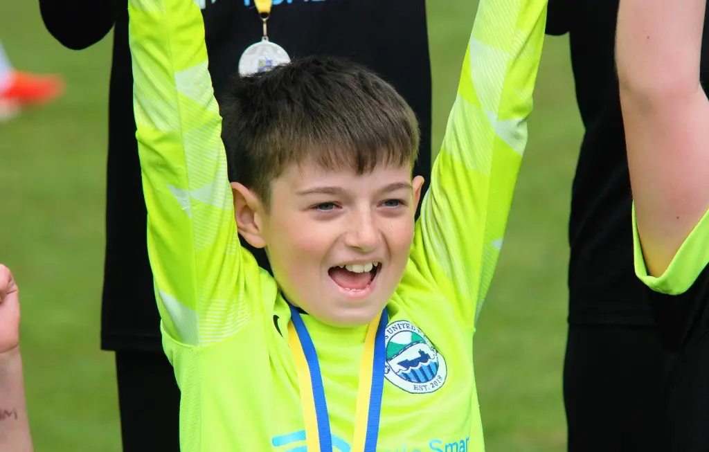 Young goalkeeper celebrating with Glens United